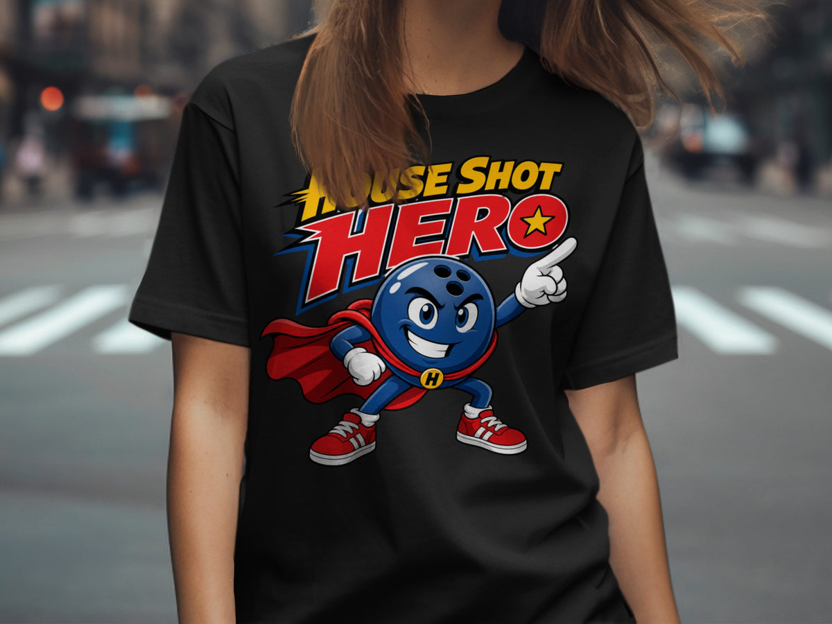 A person wearing a black t-shirt printed with a cartoon bowling ball superhero and text reading HOUSE SHOT HERO.